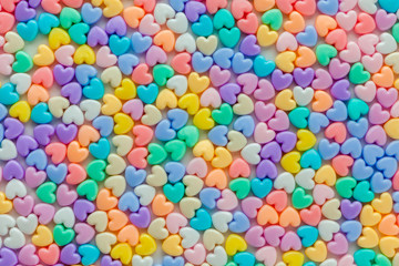 Colorful pastel of heart shaped beads on white background, use a
