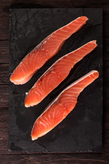 Fillet of salmon on dark wooden background, healthy food