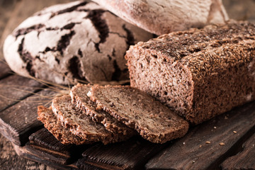 Fresh traditional bread on vintage wooden table, healthy food concept