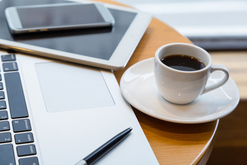 coffee cup, labtop and tablet on the round table