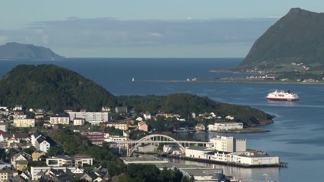 Elevated view over Alesund, Norway from Aksla as a costal ferry leaves port. The island of Godoya is in the background