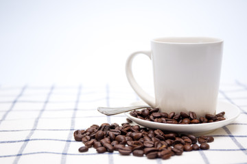 Organic coffee beans and coffe cup on tabel clsoe up.