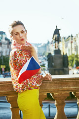 happy woman with Czech flag on Wenceslas Square blowing air kiss