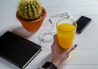 glass of juice on a table, the smart phone with headphones.