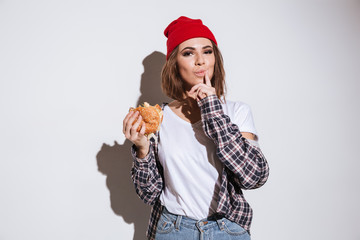 Young hungry woman eating burger