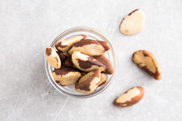 Brazil nuts in the glass bowl on stone table.