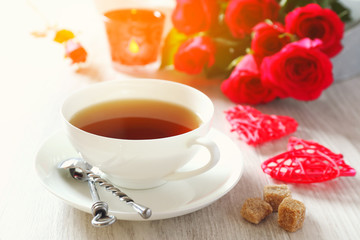  Valentine's Day: Romantic Tea drink with candle and  red roses. Toned image
