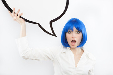 pretty young brunette caucasian woman surprised with comic baloon and blue wig on white background