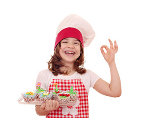 happy little girl cook with muffin and ok hand sign