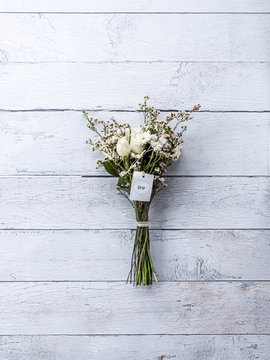 weiße rosen als strauß gebunden auf dem boden liegend von oben fotografiert