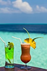 Two glasses of the soft drink are on a beach table (Maldives, The Indian Ocean)