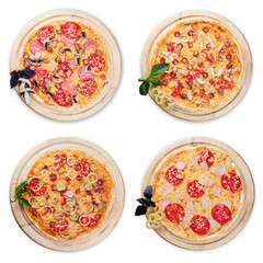 Four pizza on round wooden plates on a white background