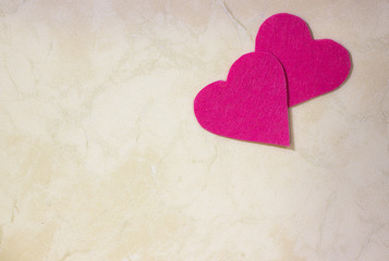 Fototapeta premium A two decorative fuchsia hearts on light background