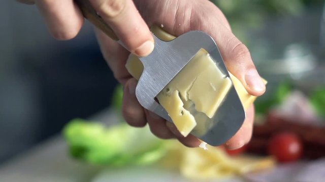 Close up of male hands slicing cheese, super slow motion 240fps
