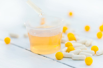 Tablets and beaker with mixture on white background