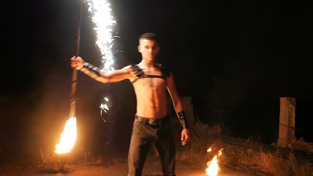 Fire show a lot of sparks in the night, young boy
