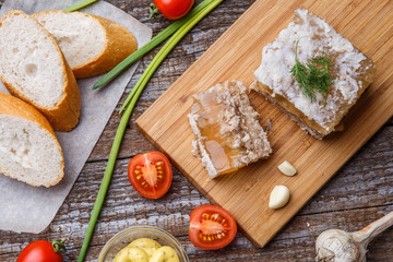 Homemade jelly meat with mustard, bread, tomatoes and garlic on the table. Holodets