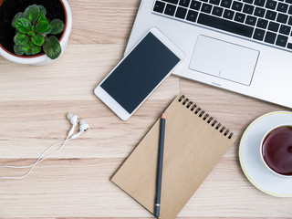 Wooden table with smartphone and Cup of tea, Desk. The view from the top