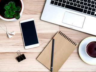 Wooden table with smartphone and Cup of tea, Desk. The view from the top