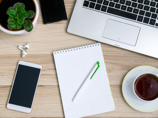 Wooden table with smartphone and Cup of tea, Desk. The view from the top
