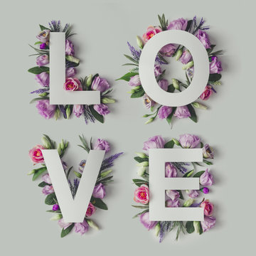 Creative layout with colorful flowers, leaves and Word LOVE. Lov