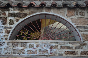 window in the stone wall with grating