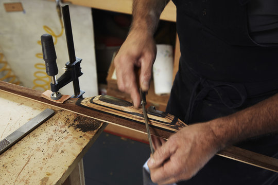 A bowman, a skilled man making a bow, in his workshop. 