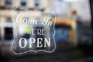 A sign etched in glass, Come In, We're Open. 