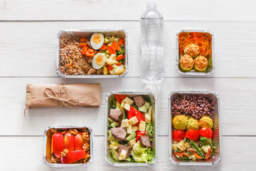 Healthy food take away in boxes, top view at wood