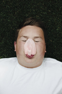 Teenage boy blowing bubble gum