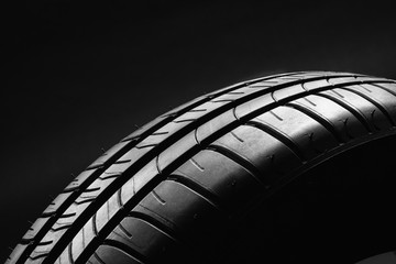 Studio shot of a summer, fuel efficient car tire on black background. Contrasty lighting and...