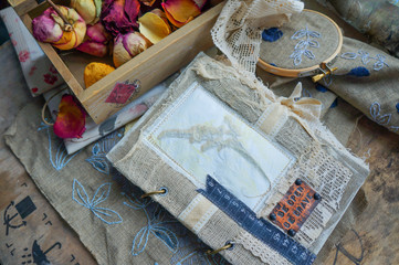 still life with a vintage notebook, dry flowers and an embroider