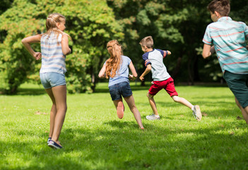 group of happy kids or friends playing outdoors