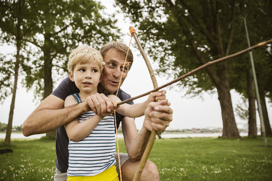 Father and son playing with self made bow and arrow