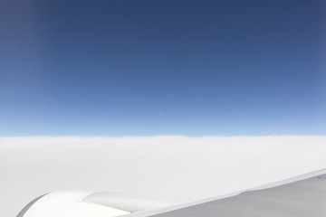 the sky when i am looking through window aircraft during flight in wing with a blue sky.