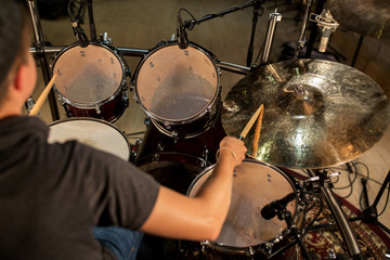 male musician playing drums and cymbals at concert