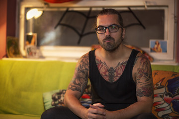 Guy is sitting in a tattoo studio.
Young handsome man customer is waiting for new tattoo.