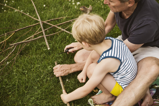 Father and son playing with self made bow and arrow