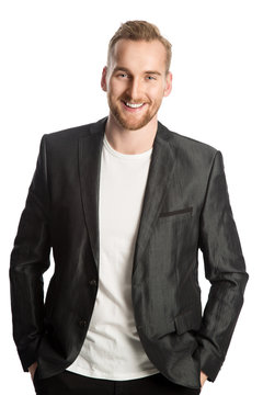 Handsome trendy man in a linen jacket standing against a white background smiling.