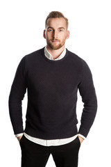 Handsome blonde mature man, standing against a white background wearing a dark sweater, white shirt and dark jeans. Feeling relaxed and confident.