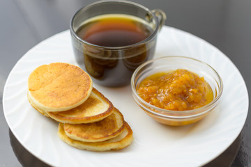 Pancakes with cloudberry jam and a cup of coffee