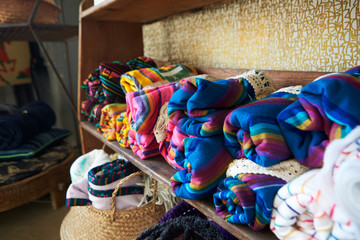 Colourful blankets displayed on shelves in a store, close up