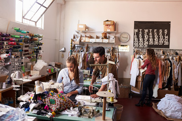 Machinist and colleagues working at a clothing design studio