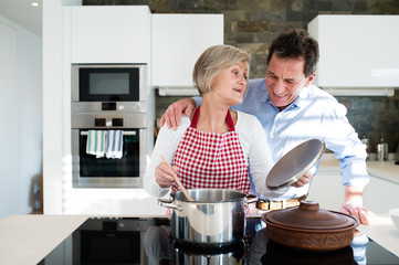 Senior couple in the kitchen cooking together.