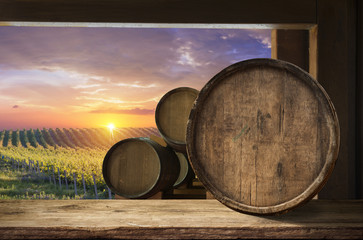 Red wine with barrel on vineyard in green Tuscany, Italy