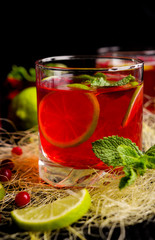Red drink with lime and mint on black background