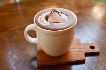 hot coffee cup on wooden table on brown background