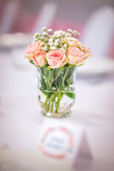 flowers of roses on wedding table with card, romantic pink background for party or event