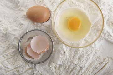 jajko kurze w miseczce na tle mąki © npls