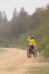 mountain bicycle man drinking fresh water from bottle on dirt tr